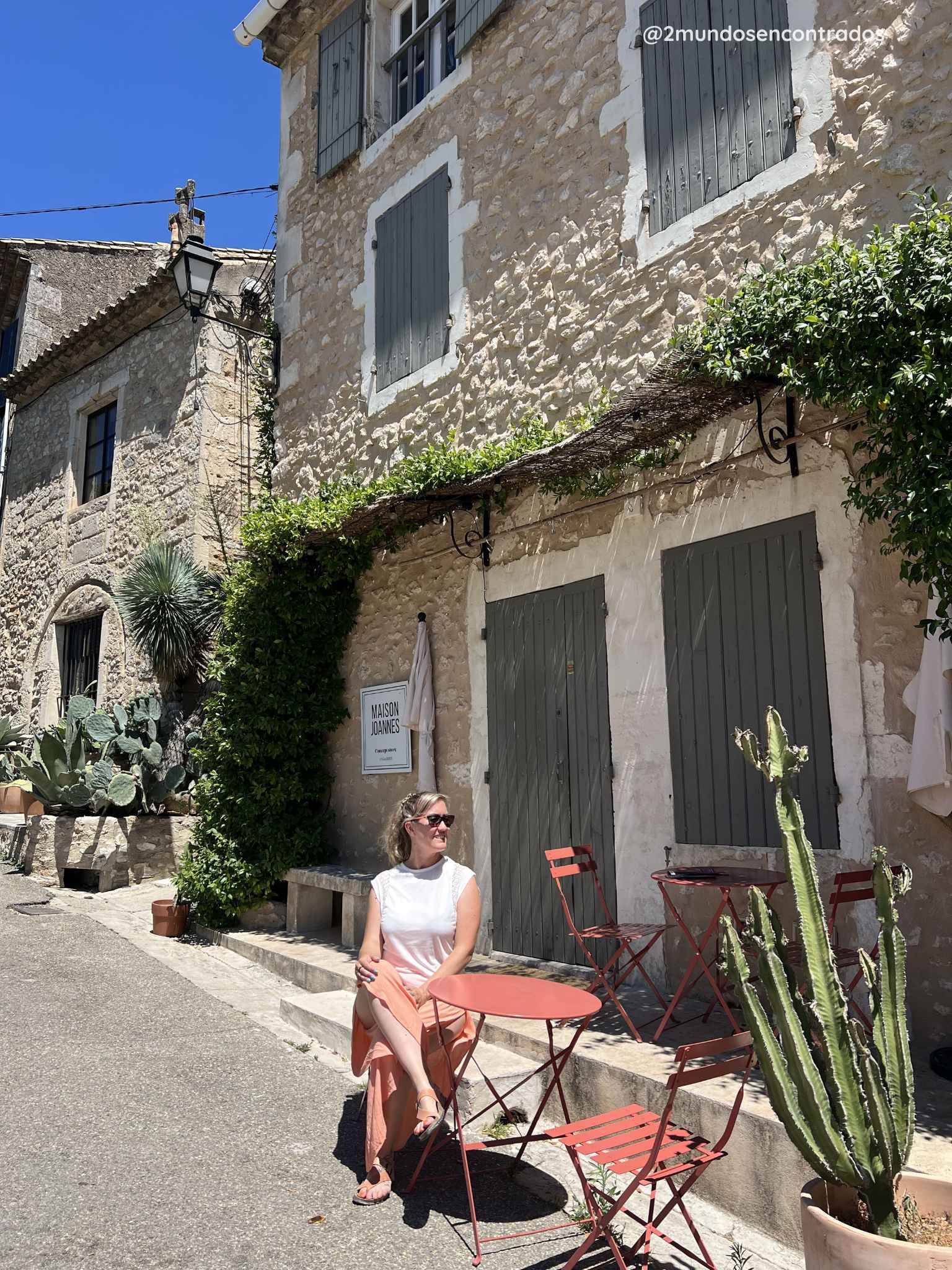 Eva sentada en una terraza frente a una casa de piedra tradicional en Eygalières, uno de los pueblos más bonitos de la Provenza francesa.