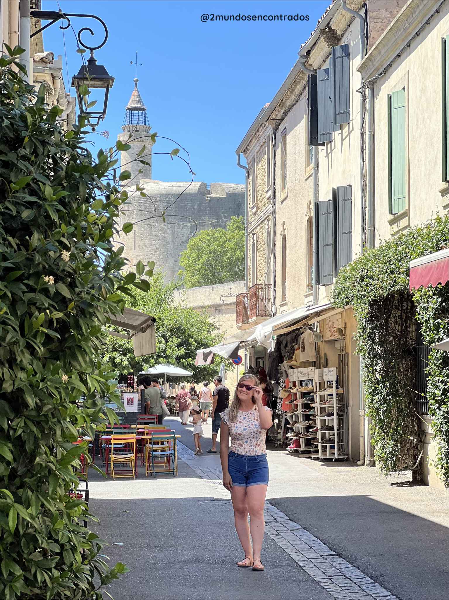 Eva paseando por una calle empedrada y comercial del centro histórico de Aigues-Mortes, con las murallas medievales al fondo. Qué ver en la Provenza en 11 días