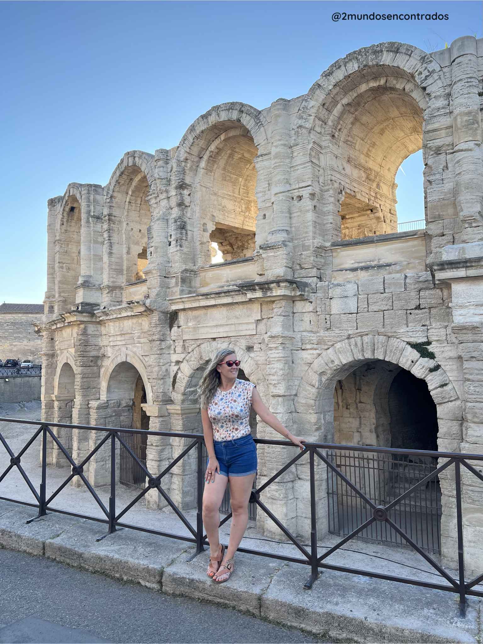 Eva junto a la fachada de piedra y los arcos antiguos del Anfiteatro de Arlés, un monumento romano imprescindible en la Provenza.