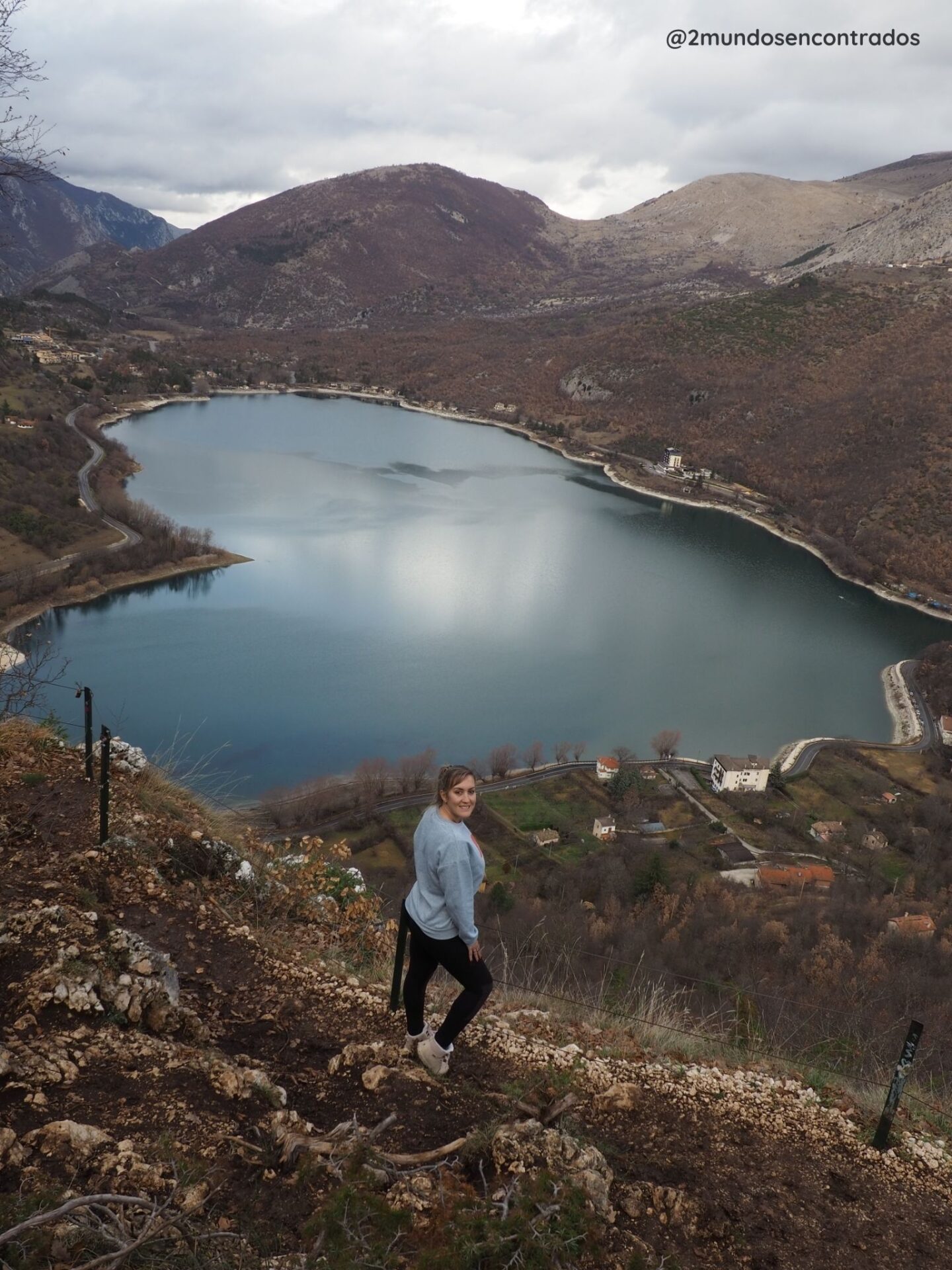 Lago de origen natural con reflejos de montañas y cielo.