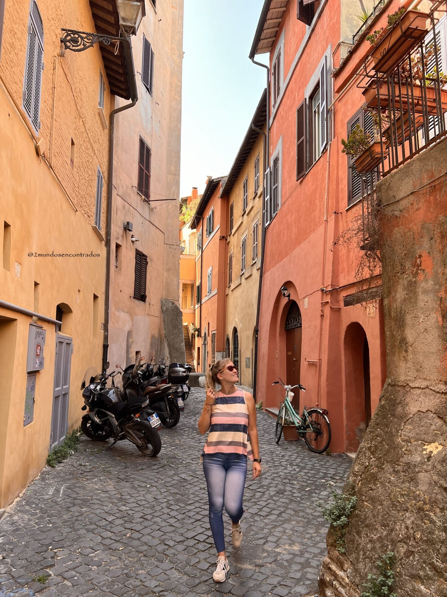 Calles empedradas del barrio de Trastevere con fachadas llenas de flores
