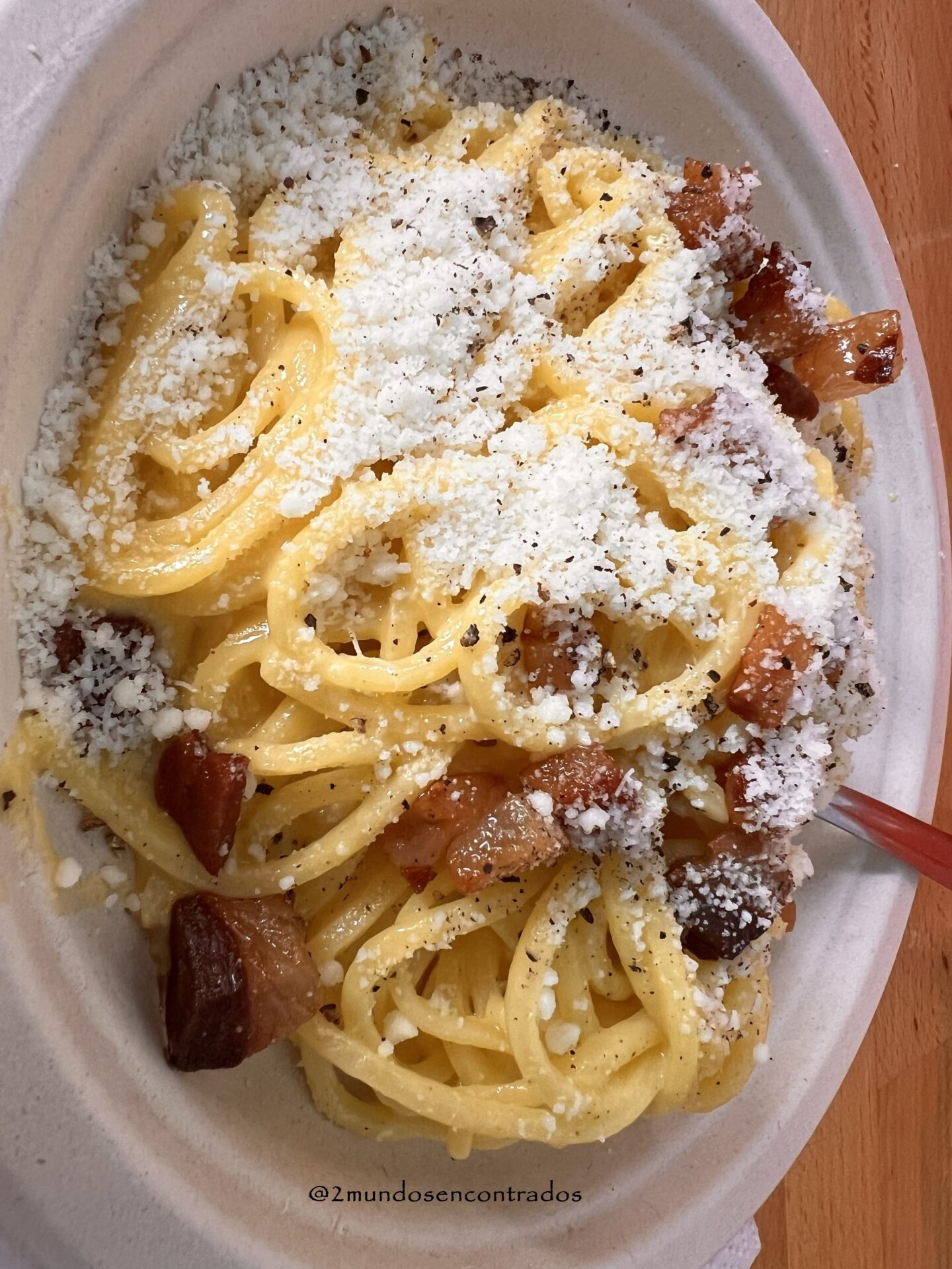 Plato de pasta a la carbonara con salsa cremosa y queso rallado por encima