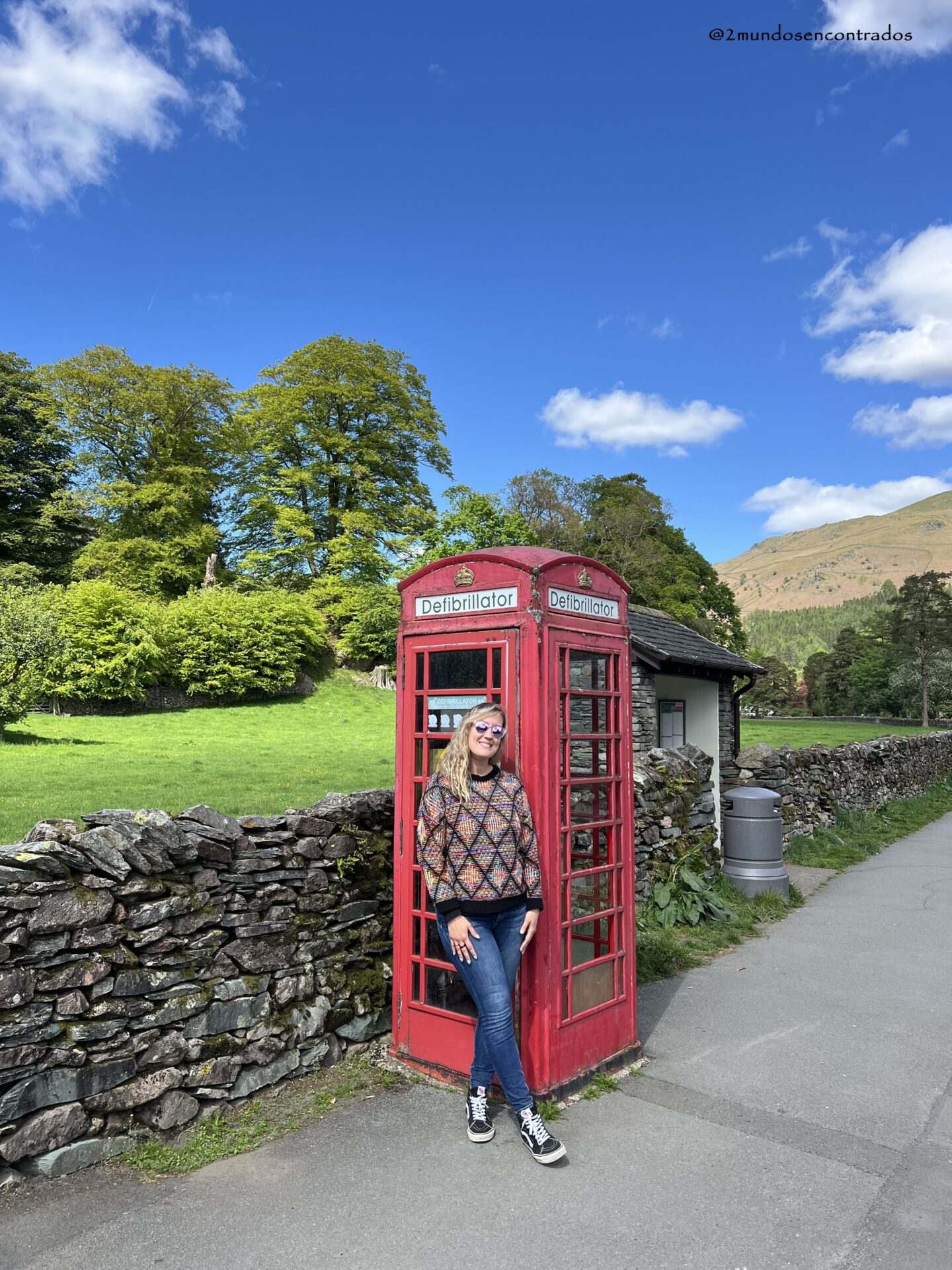 Cabina telefónica roja tradicional en Grasmere rodeada del paisaje típico del Lake District.