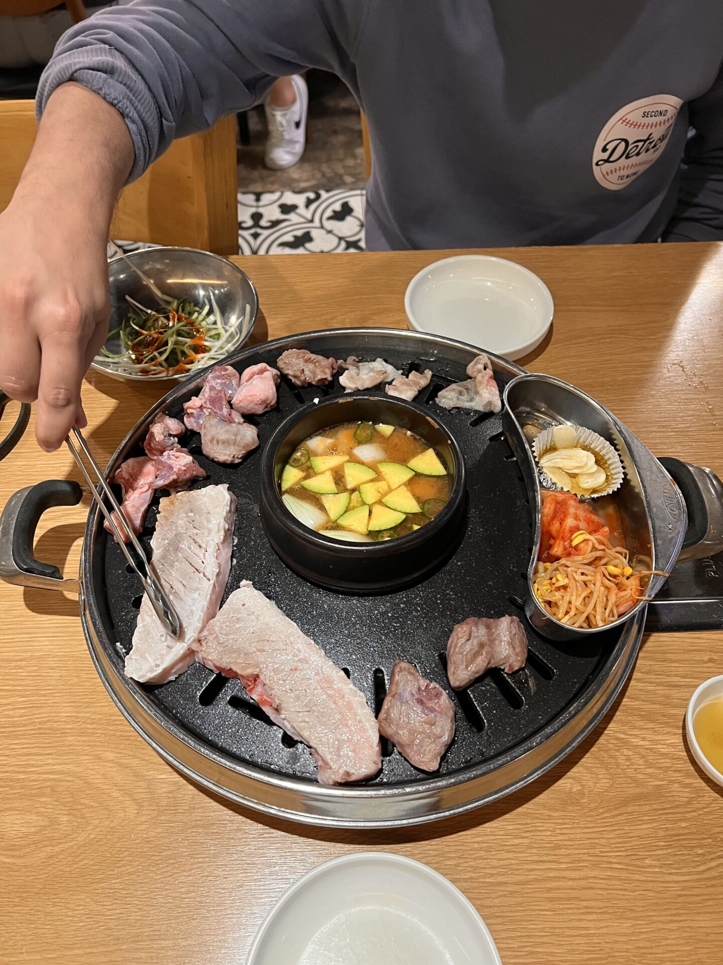 Parrilla con carne de cerdo, sopa y acompañamientos tradicionales durante una comida de barbacoa coreana en un restaurante de Seúl, Corea del Sur.