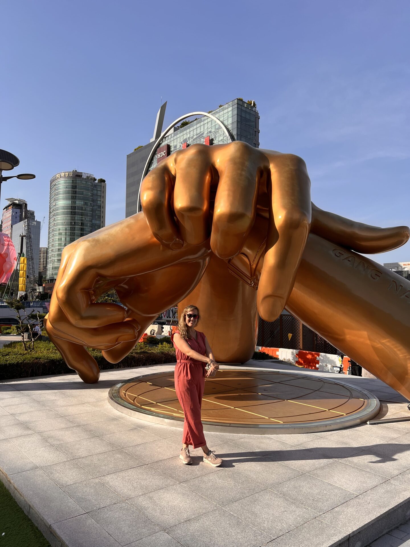 Visitante posando frente a la escultura gigante de manos de Gangnam Style en el distrito de Gangnam, Seúl. - Qué ver en Seúl en 4 días