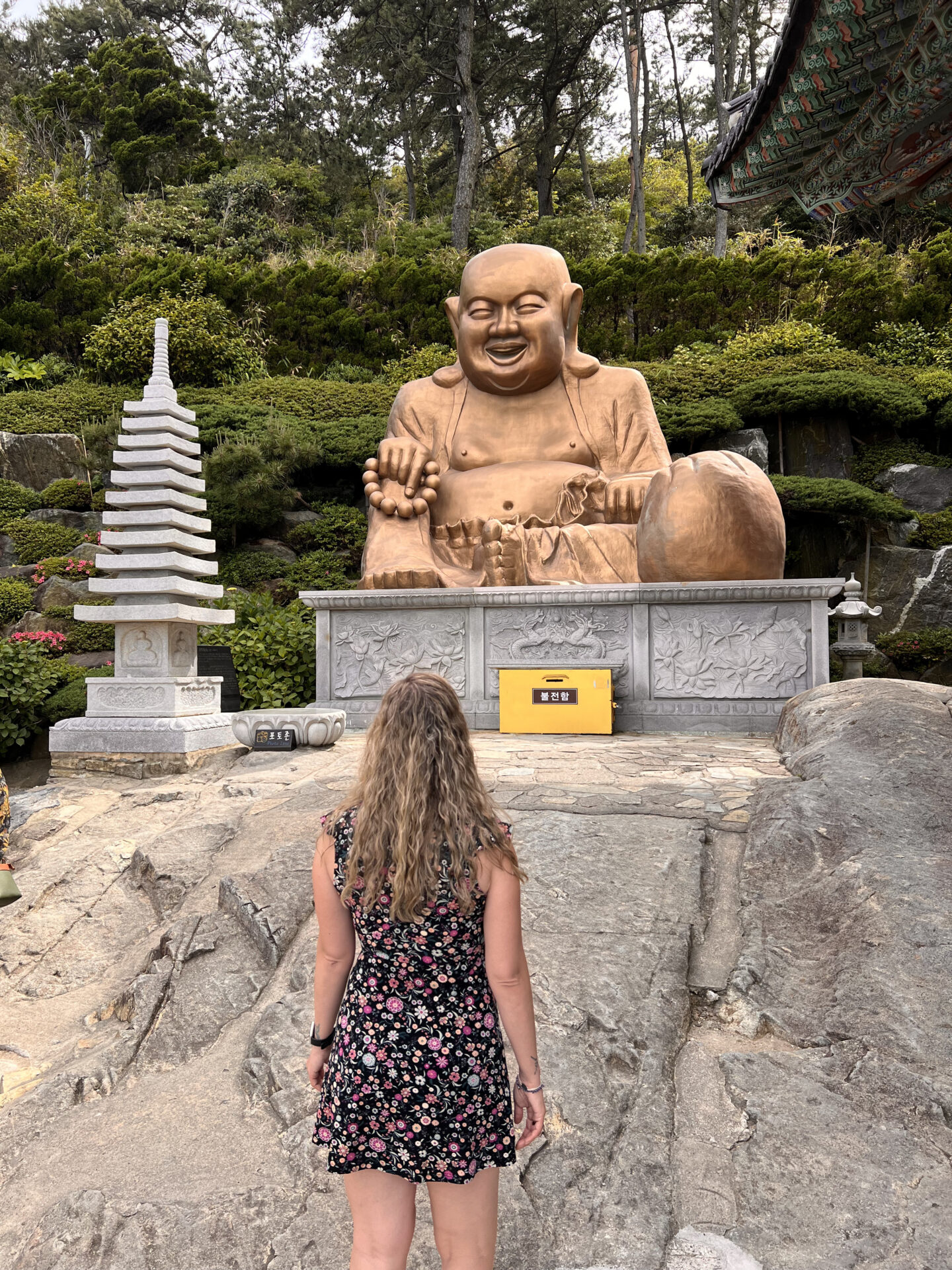 Eva frente a la gran estatua del Buda sonriente en el templo Haedong Yonggungsa de Busan, Corea del Sur. Qué ver en Busan en 3 días