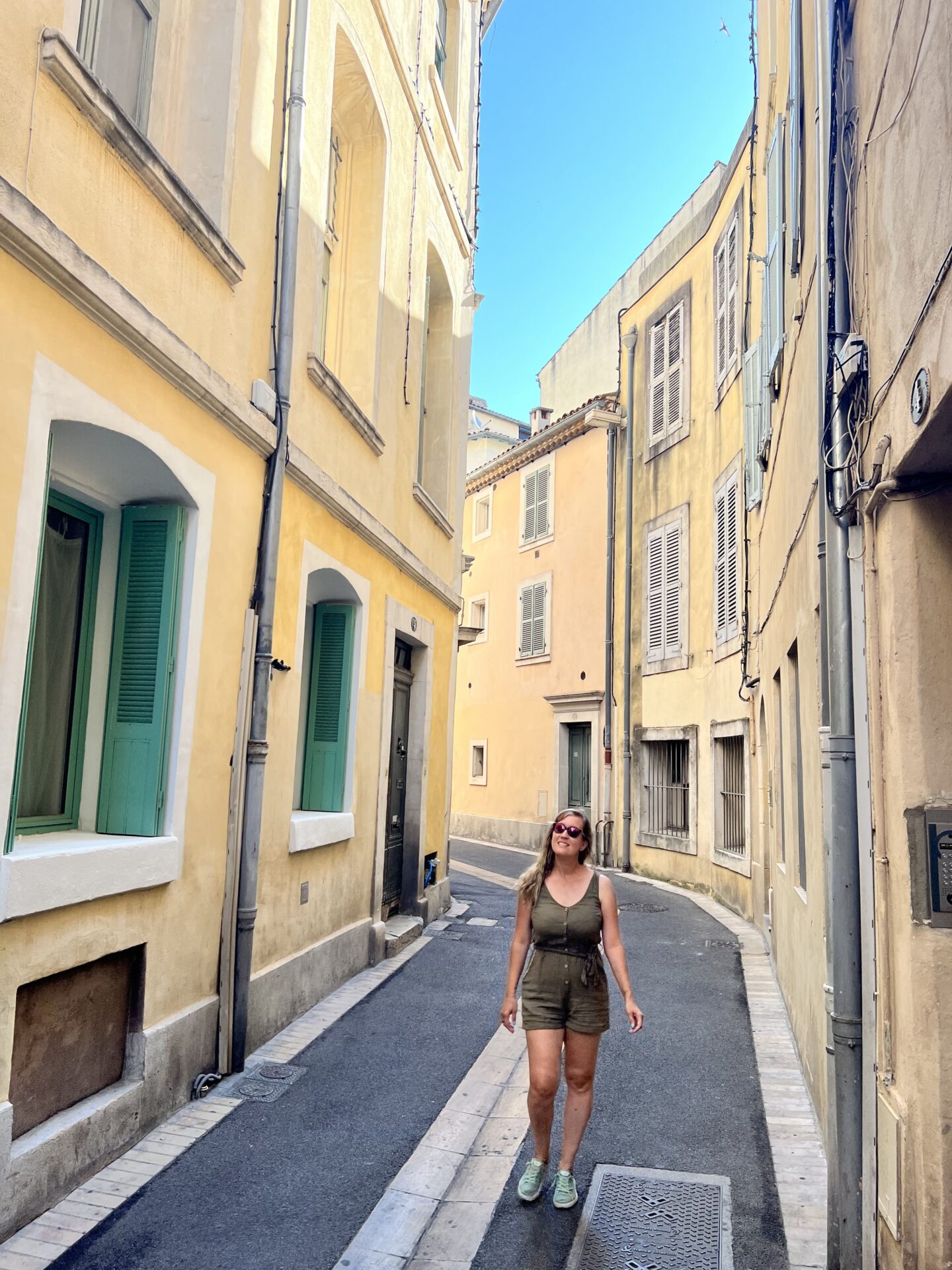 Calle con edificios tradicionales en el centro histórico de Nimes, ideal para recorrer a pie durante una visita a la ciudad.