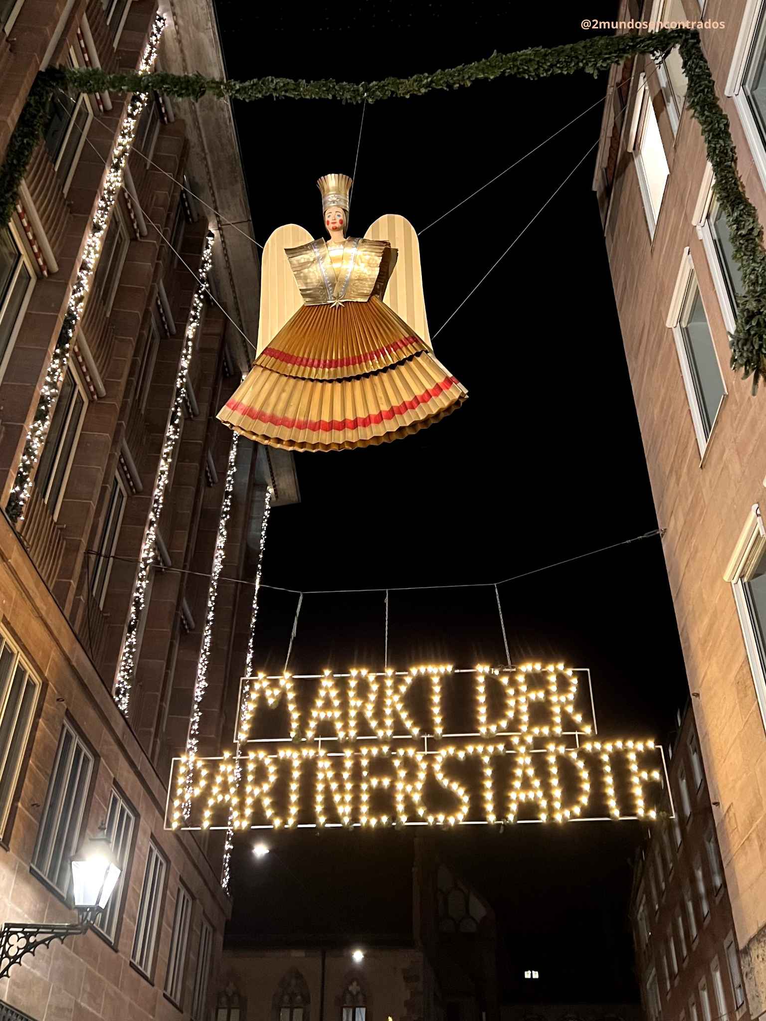 Decoración con un ángel iluminado sobre una calle del centro histórico de Núremberg durante la Navidad.