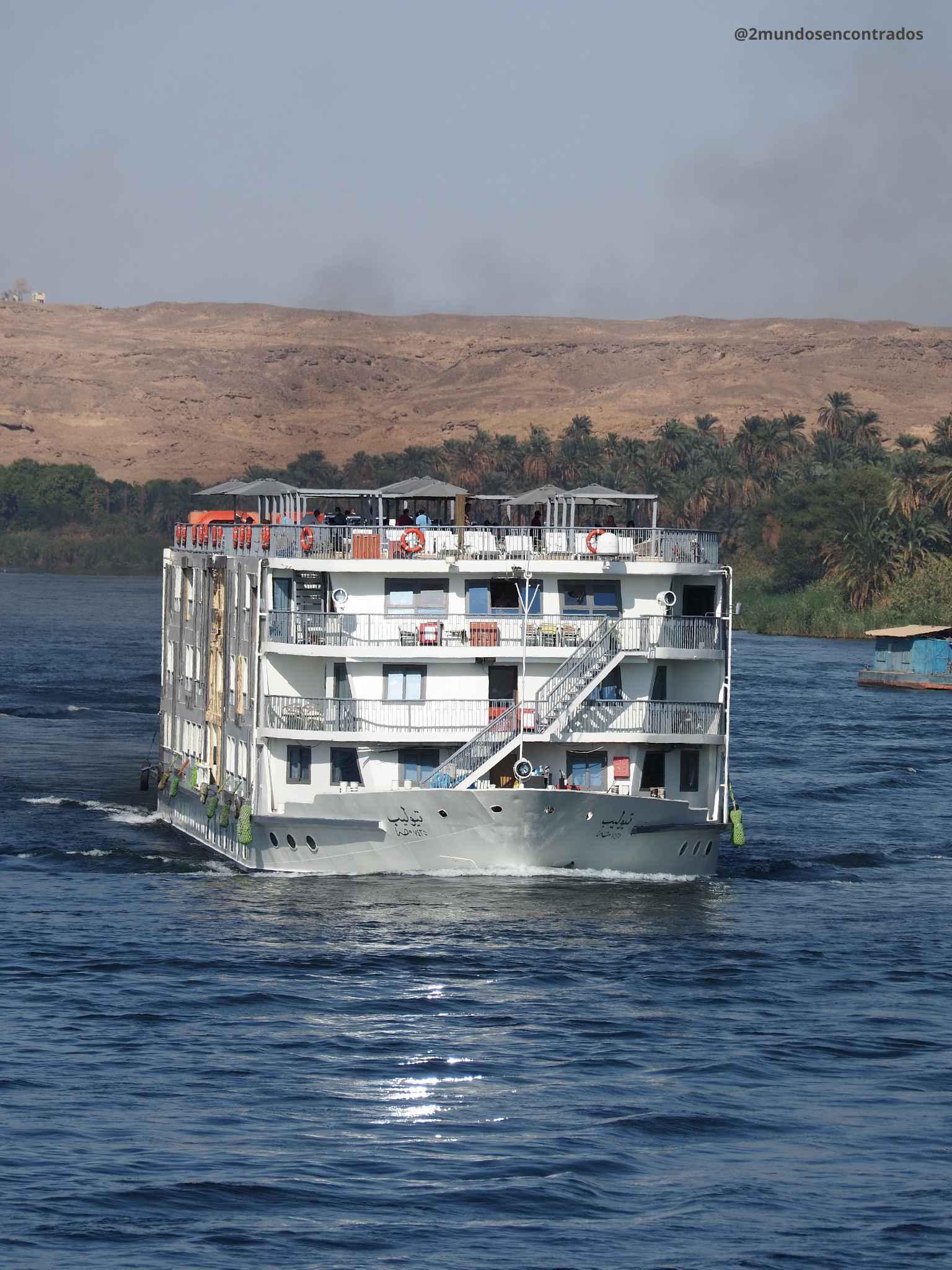 Crucero navegando por el río Nilo junto a palmeras y montañas en Egipto