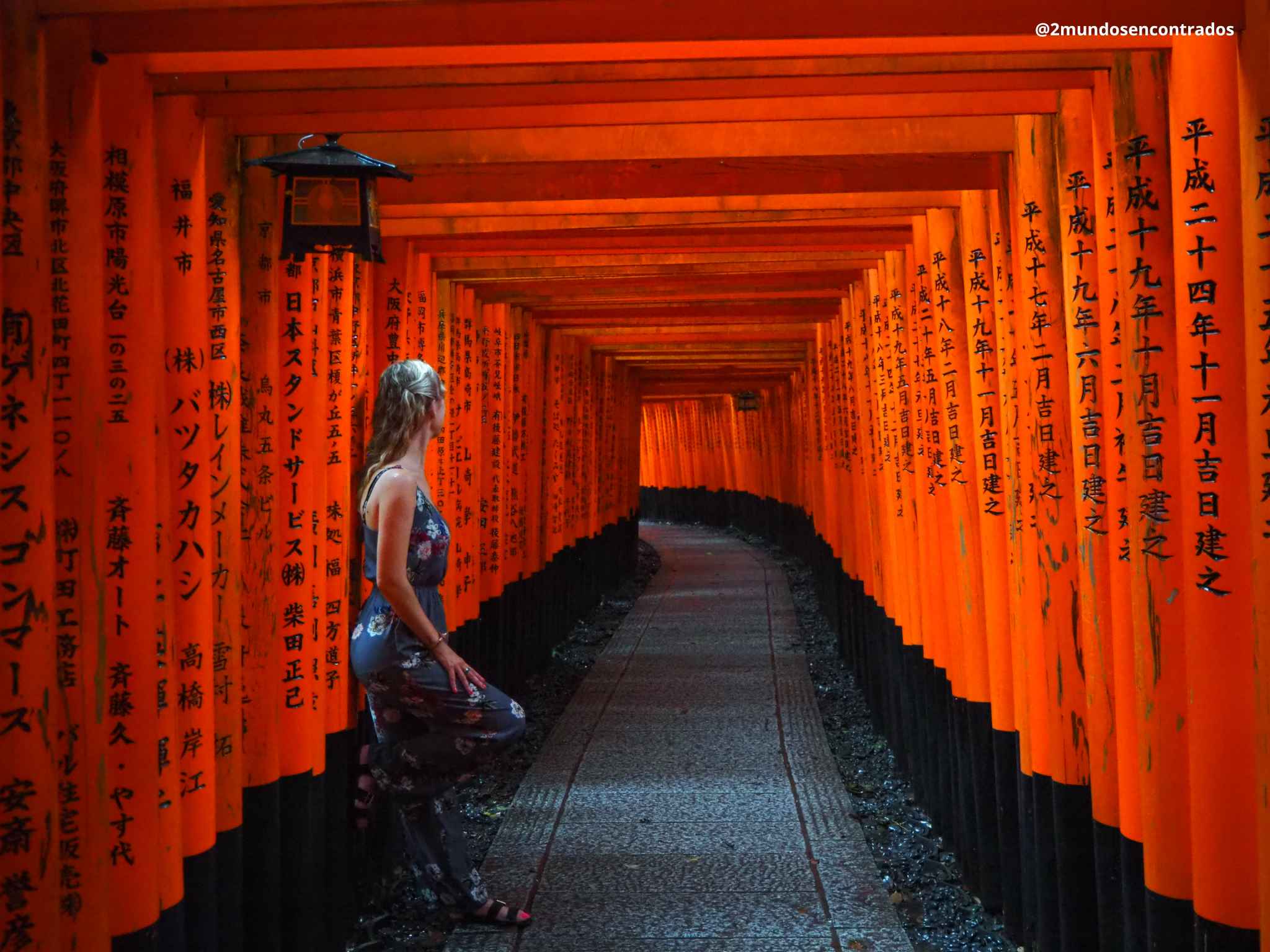Eva contemplando el famoso corredor de miles de torii rojos del santuario Fushimi Inari Taisha en Kioto, Japón.