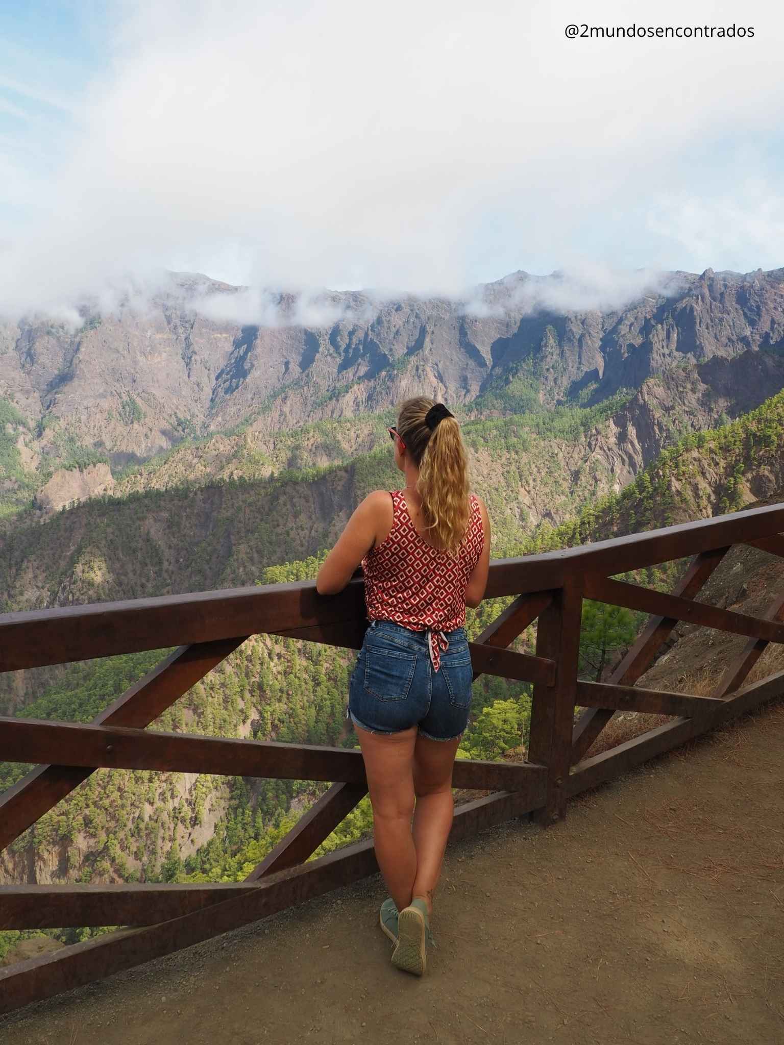 Eva asomada a la barandilla del mirador contemplando el majestuoso circo de la Caldera de Taburiente en La Palma.
