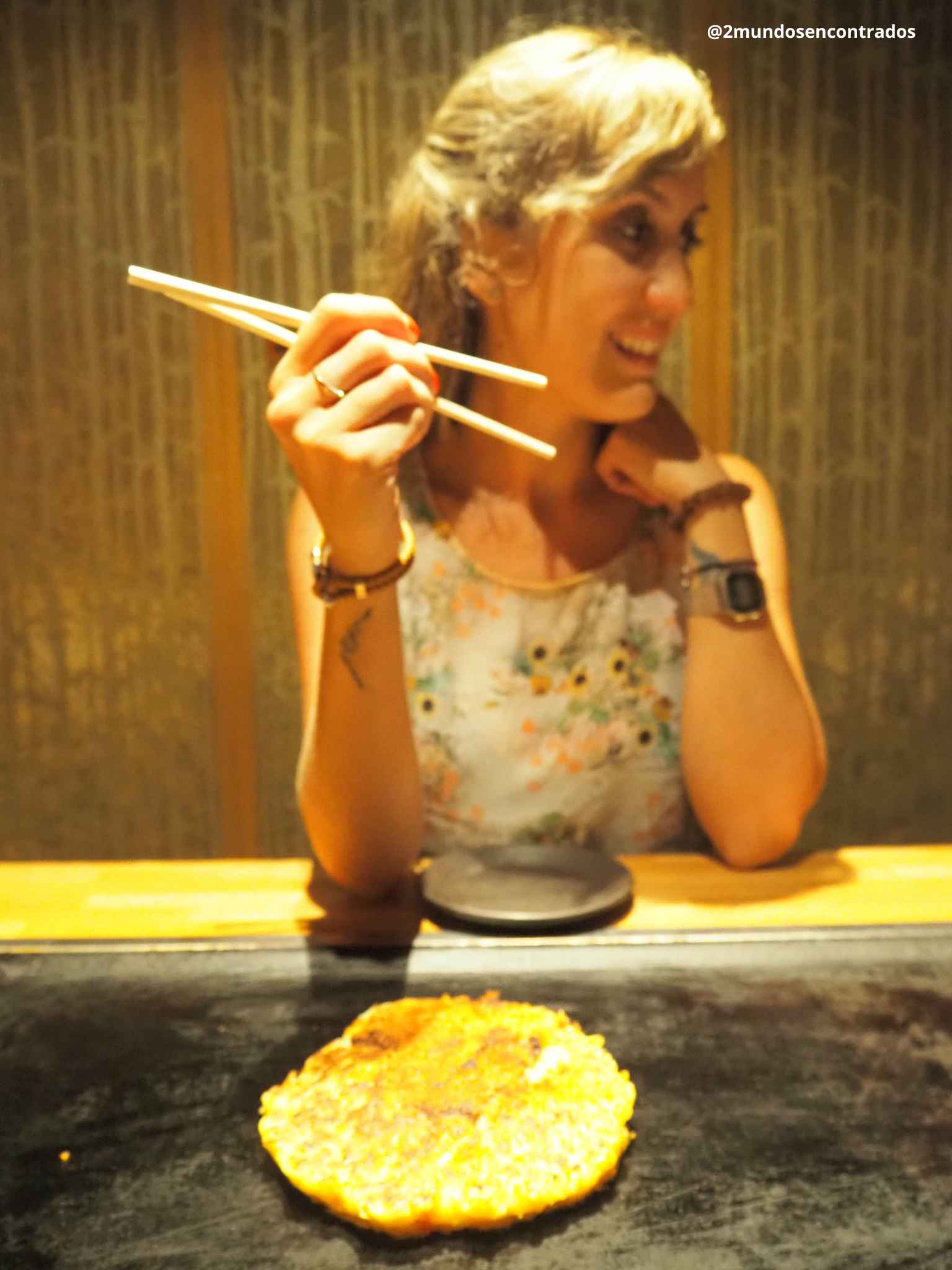Probando un okonomiyaki en un restaurante tradicional de Kioto, Japón.