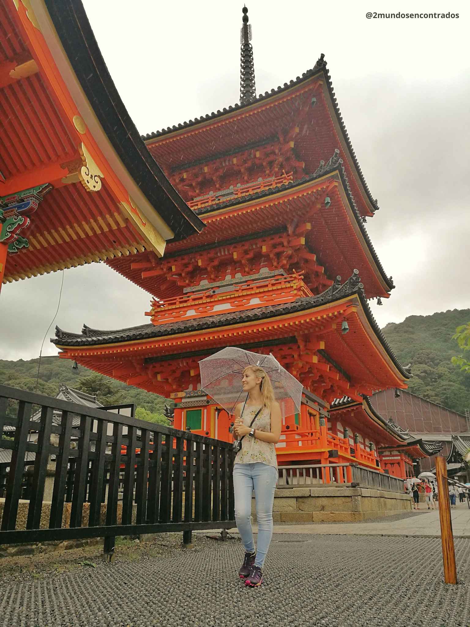 Templo Kiyomizudera en Kioto, Japón, con una viajera bajo un paraguas en un día lluvioso.