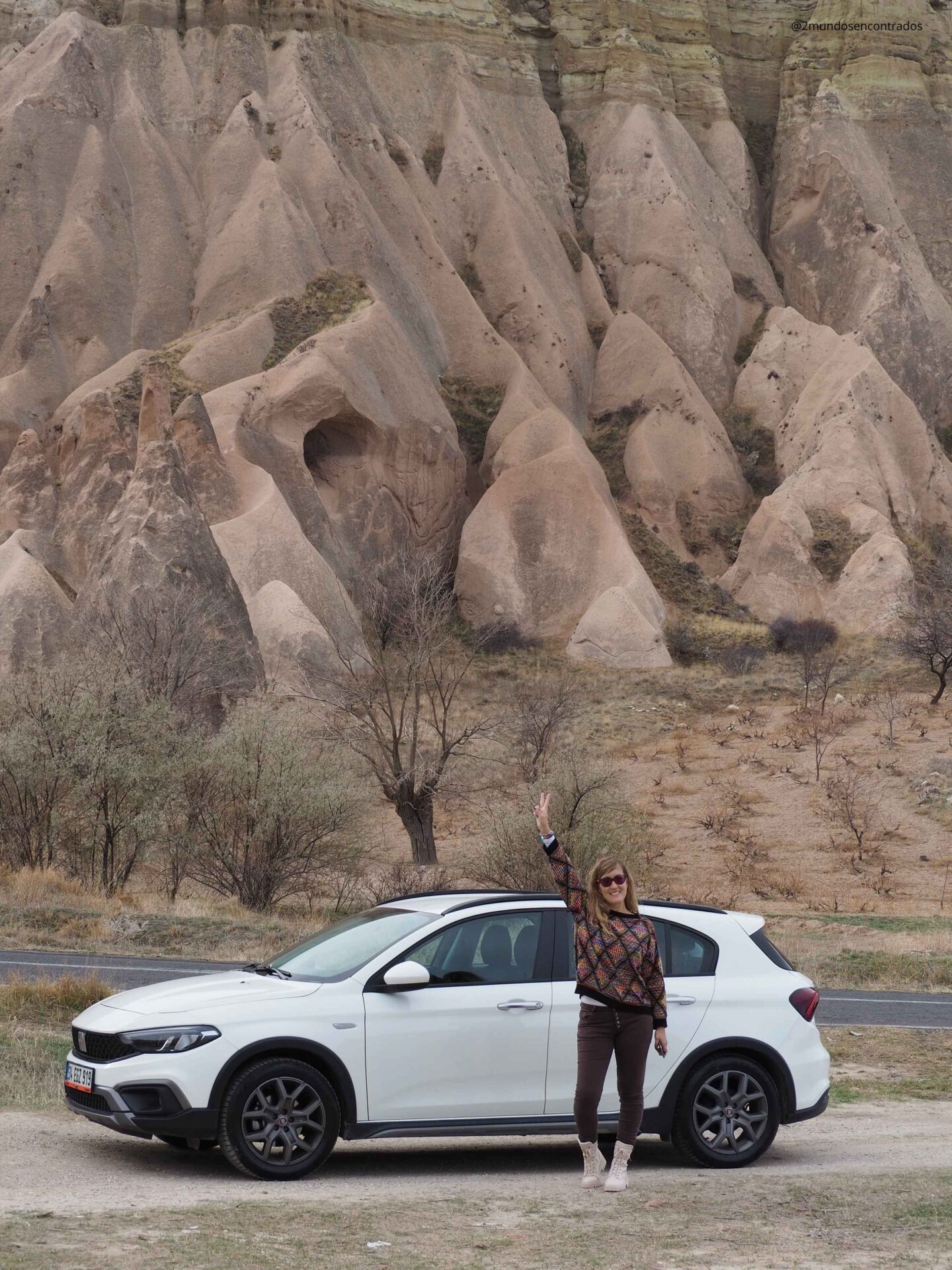 Eva junto al coche de alquiler en un paisaje de Capadocia, Turquía