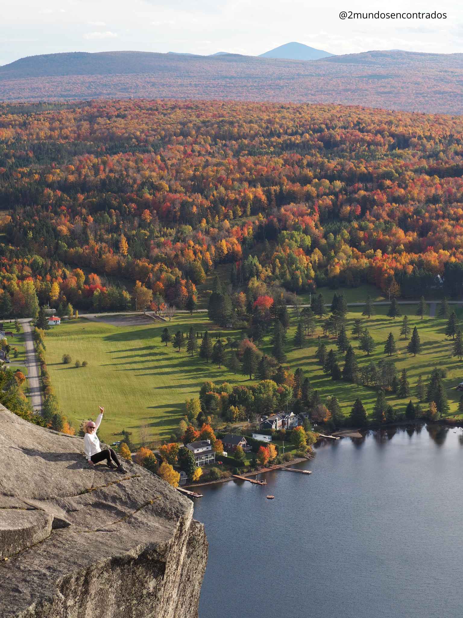 Eva sentada en el peñasco del Mont Pinacle contemplando el paisaje de otoño y el lago. Qué ver en Québec en 10 días