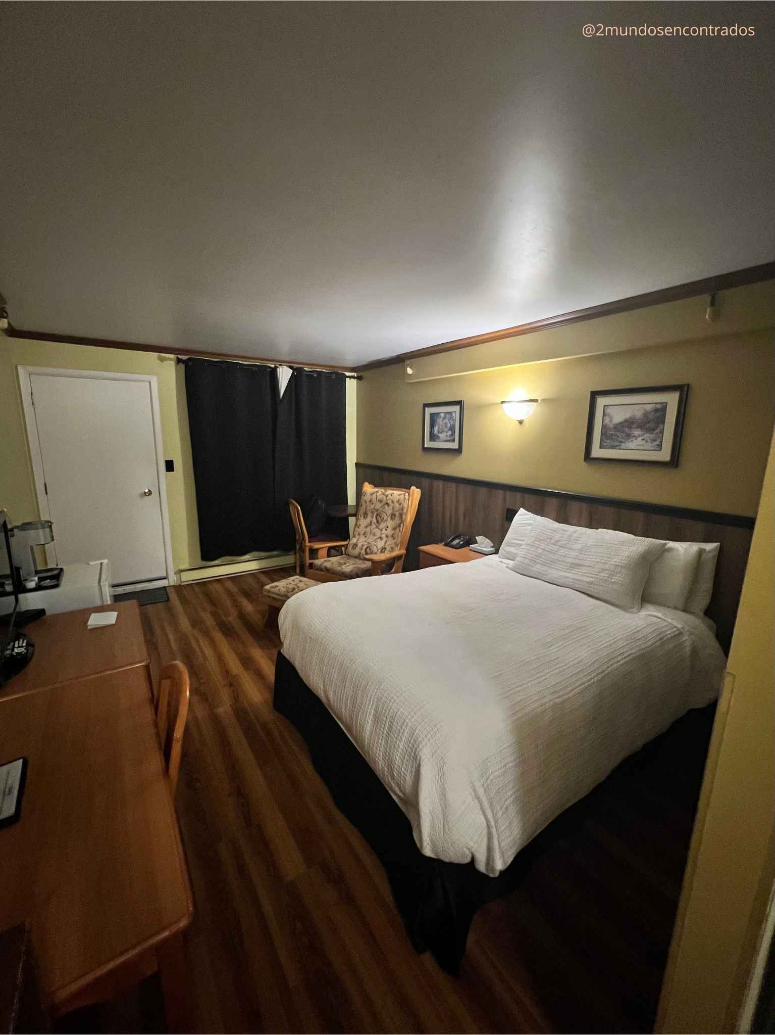 Habitación de hotel acogedora con cama grande y suelo de madera en la ruta por Québec.