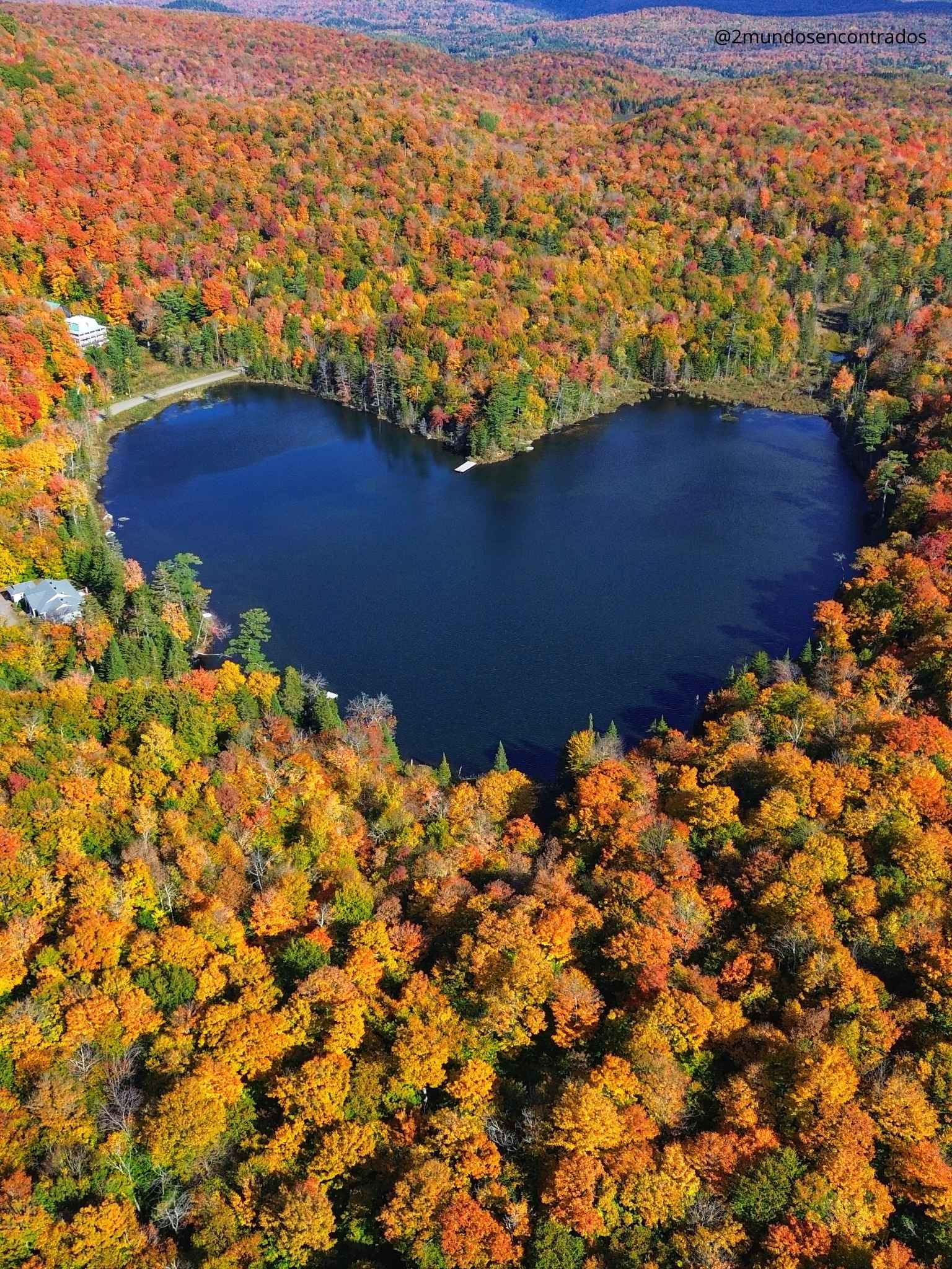 Qué ver en Québec en 10 días. Vista aérea del lago Étang Baker en forma de corazón rodeado de frondoso bosque otoñal.